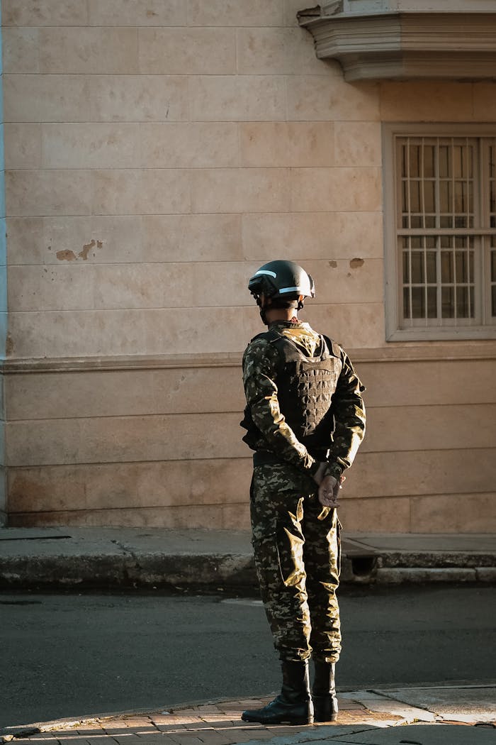 About A soldier in uniform stands guard in a city street, illustrating urban security in Colombia.